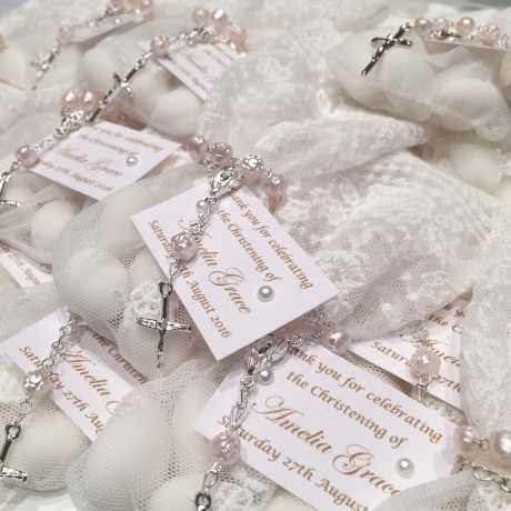 White lace bonbonniere bags with pink mini rosary beads